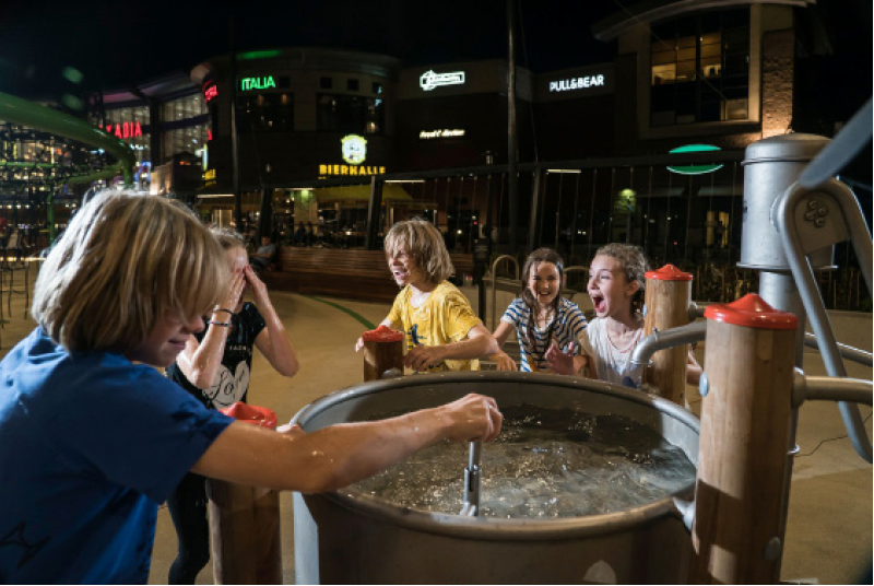 Fußgängerzone Hauptbild,Kinder spielen in der Fußgängerzone mit einem Spielgerät in dem Wasser drinnen ist von Kaiser und Kühne