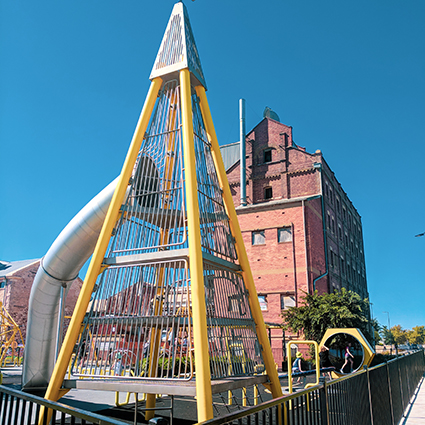 Harts Mill Projekt, die Pyramide mit Rutsche ist im Vordergrund des Spielplatzes und dahinter ist ein Gebäude