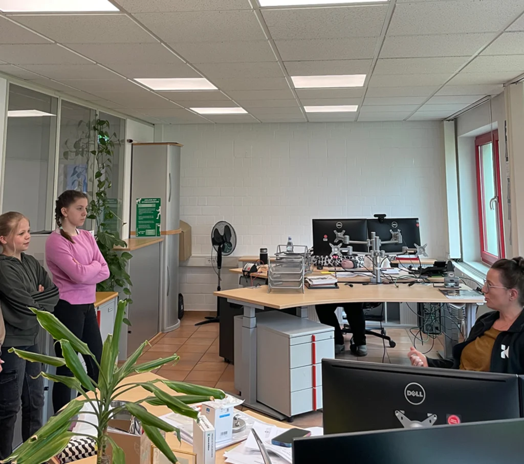 Children in the office at Kaiser and Kühne listening to the employee.